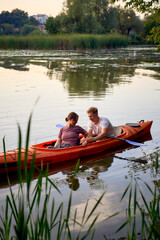 the couple in love kayaking on the river at sunset