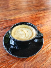 Latte coffee with milk on wood background