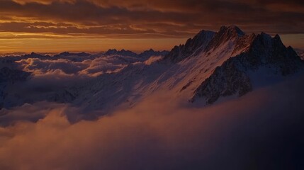 Naklejka premium A high-angle shot of snowy mountains covered with clouds during a dark evening , ai