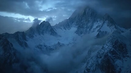 Fototapeta premium A high-angle shot of snowy mountains covered with clouds during a dark evening , ai