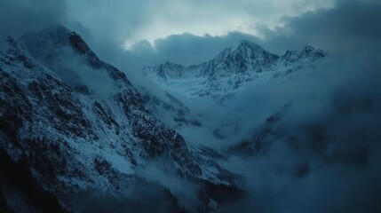Obraz premium A high-angle shot of snowy mountains covered with clouds during a dark evening , ai