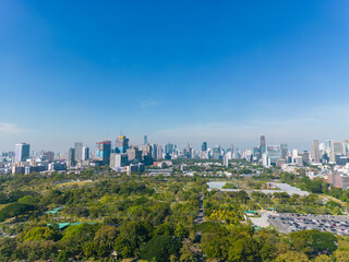 Naklejka premium Aerial view modern office building with tropical green tree park in Benchakitti public park downtown