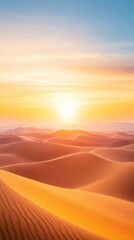Aerial of a vast desert landscape with rolling sand dunes and the setting sun casting a golden hue over the horizon