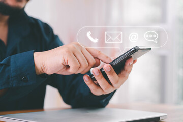 Fototapeta premium Concept of contact us, customer support, service, icon, Contact us or Customer support hotline people connect. Businessman using a laptop with the (email, call phone, mail) icons. customer service.