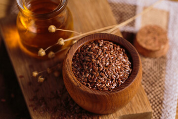 Brown linen seeds, flaxseed vegetable oil on rustic wooden background. Healthy super food