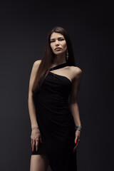 Naklejka premium A stylish woman in a sophisticated black dress and chic accessories strikes a confident pose. Embodies class, elegance, and fashion.