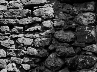 Old Stone Wall Background Divided by Sunlight: Light and Shadow – Duality Concept. Black and white.
