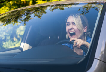 Stressed woman drive car feeling sad and shocked. Caucasian blond girl shouting and feeling frustrated.