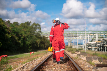 Surveyor engineers team wearing safety uniform and blueprint checking inspection by theodolite telescope to measurement level position railway construction site is industry transportation concept.