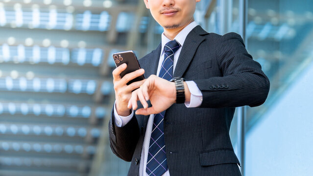 腕時計を見る日本人男性ビジネスマン