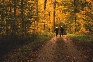 couple with pumpkin head in fall forest