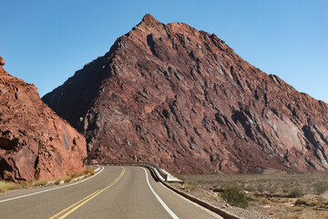 Ruta al lado de monta&ntilde;as rojizas.