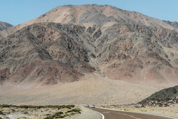 Inmensa montaña al lado de la ruta con autos.