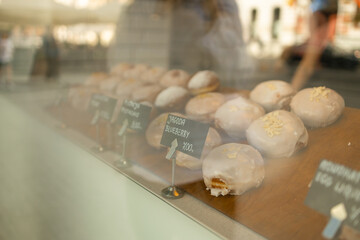 Close of up of a variety of color glazed doughnuts on a window display of a cafe at Krakow, desserts and donut display board. High quality photo