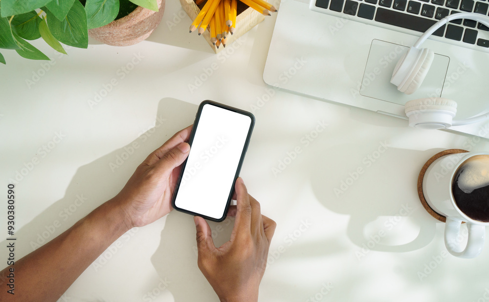 Canvas Prints overhead view of hands holding smartphone with blank screen on white office desk.