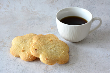 a cup of coffee next to some sugar cookies