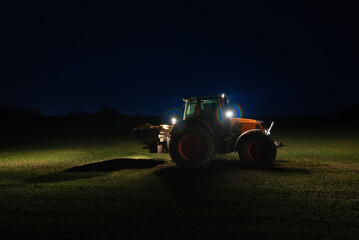  Agricultural tractor with headlights at night