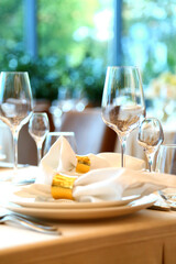 Table setting in a restaurant. Empty glasses set in restaurant. Table setting with glasses, cutlery and plates. Restaurant interior.