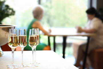 Champagne on the table at the restaurant. Champagne on a table in a restaurant with people sitting in the background.