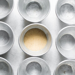 Overhead of moi moi mixture in silver pans, top view of nigerian bean pudding about to be steamed in steel pans, process of making nigerian moi moi