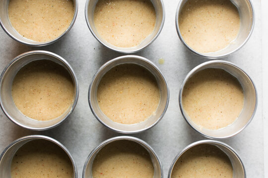 Overhead of moi moi mixture in silver pans, top view of nigerian bean pudding about to be steamed in steel pans, process of making nigerian moi moi