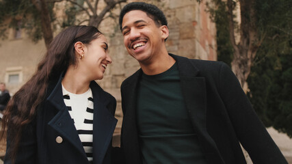 Stylish young couple posing in front of historic cathedral facade, showcasing urban fashion and togetherness