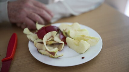Close-up of sliced apple and peels on a plate, highlighting the simplicity and freshness of a healthy snack prepared with love and care