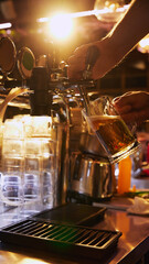Bartender pouring beer from tap into glass mug, with bar counter and beer taps in the background. Bar aesthetic. Concept of beer, brewery, pub, Oktoberfest, traditions