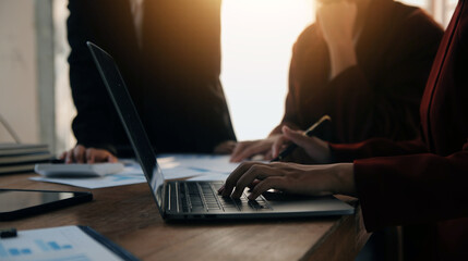 Group of confident business people point to graphs and charts to analyze market data, balance sheet, account, net profit to plan new sales strategies to increase production capacity.