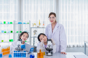portrait female scientist as a mentor is teaching the students, kids studying science in laboratory