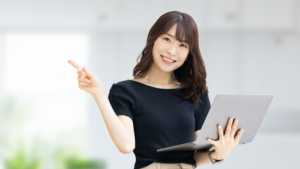 ノートパソコンを持つビジネスウーマン