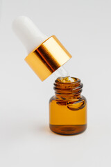 Small cosmetic jar with glass pipette. Serum, skin care or medicine. On light background.