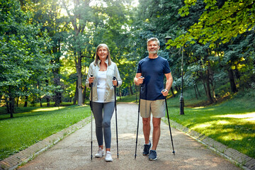 Active and Engaged Seniors Delight in a Nature Walk in the Park Using Nordic Poles