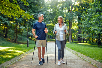 Active and Engaged Seniors Delight in a Nature Walk in the Park Using Nordic Poles