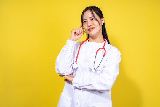 A woman in a white lab coat is standing in front of a yellow background