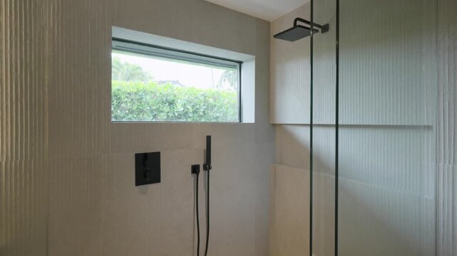 Close up inside of walk in shower cabin with corrugated walls and built in rectangular window at top. Multifunctional plumbing for changing water supply modes during bathing
