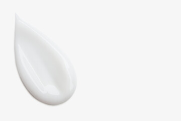 A smear of white cosmetic cream on a light background.
