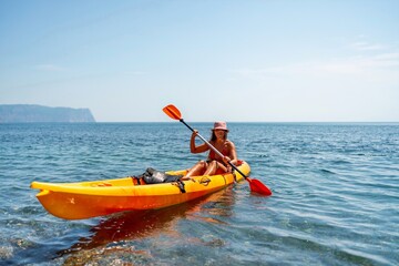 Kayak sea woman. Happy attractive woman with long hair in red swimsuit, swimming on kayak. Summer holiday vacation and travel concept.