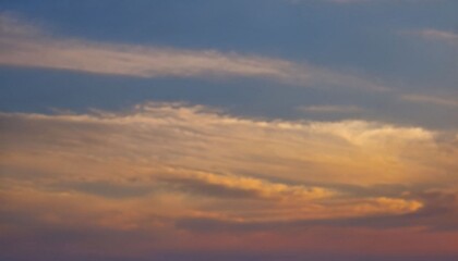 Obraz premium The sun dips below the horizon, casting a warm glow across the sky. Wispy clouds catch the last rays, their edges tinged with hues of orange and pink. A tranquil dusk scene. AI generated.