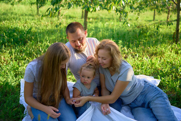 Fototapeta premium a family of four on a picnic in the park