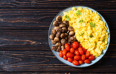Homemade scrambled eggs with mushrooms and cherry tomatoes