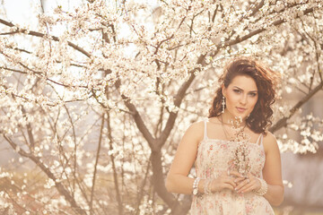 Spring girl face. Close up portrait of tender woman at sakura flowers background.