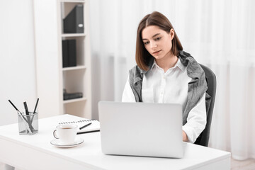 Teenager working with laptop at home. Remote job