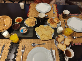 Moroccan breakfast ftour, msemen, baghrir, orange juice, pastries, table setup morning meal traditional dishes