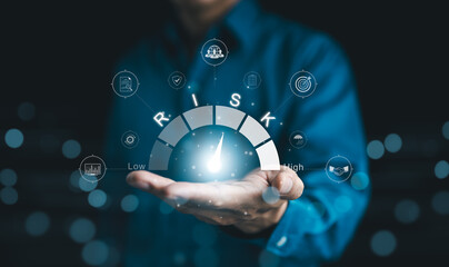 Risk Management and Assessment Concept. A person holding digital risk gauge in their hand, with...