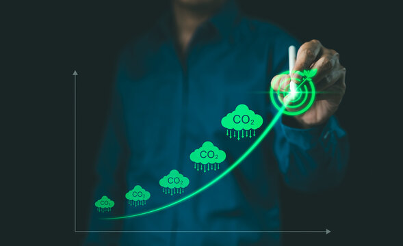 CO2 Emission Reduction and Environmental Sustainability. Person drawing rising chart with digital icon CO2 emissions, the concept of reducing carbon dioxide emissions for environmental sustainability.