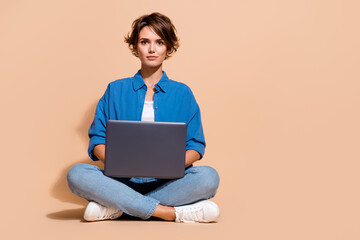 Full body size photo of young woman employee in coworking with laptop casual it specialist copyspace isolated on beige color background