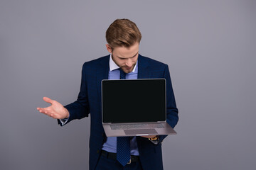 Businessman show video on laptop isolated on grey. New business app. Online banking service. Product proposal. Advertisement presentation, copy space. Businessman presenting laptop app. Video call