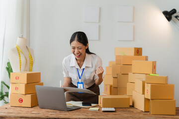 Ecommerce Success - Celebrating a Milestone: Young Asian entrepreneur overjoyed with online sales...