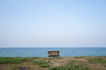 Public chair on the beach overlooking endless sea view.